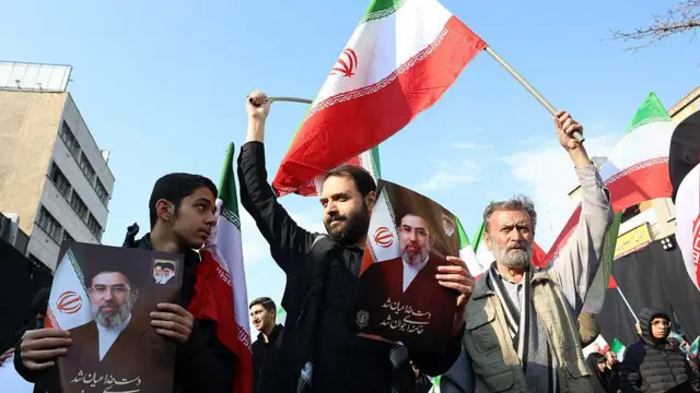 सोमवार को तेहरान के इंक़लाब चौक पर लोगों ने नए सर्वोच्च नेता अयातुल्ला मोजतबा खामेनेई के समर्थन में आयोजित रैली में प्रदर्शनकारियों ने ईरानी झंडे लहराए और उनकी तस्वीरें पकड़ीं.