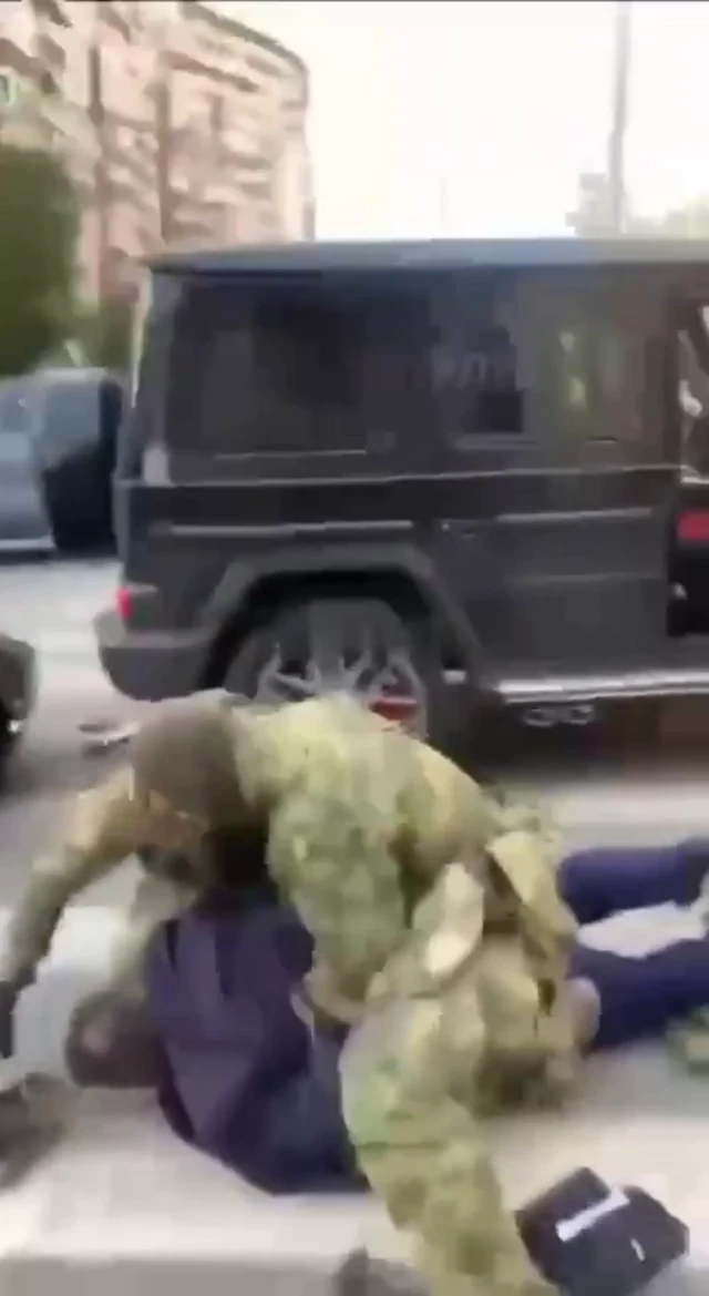 Сотрудники ФСБ кладут на землю мужчину в костюме у джипа