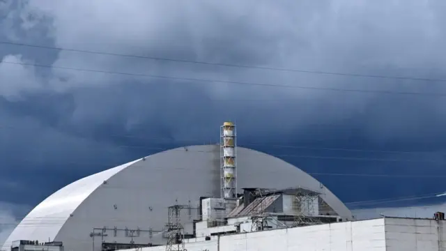 Imagem de parte a usina nuclear desativada de Chernobyl sob um céu carregado de nuvens