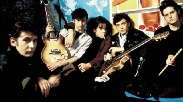 Филм Бекбит из 1994. године бавио се односом Џона Ленона (Ијан Харт, лево спреда) и „петог Битлса" Стјуарта Сатклифа