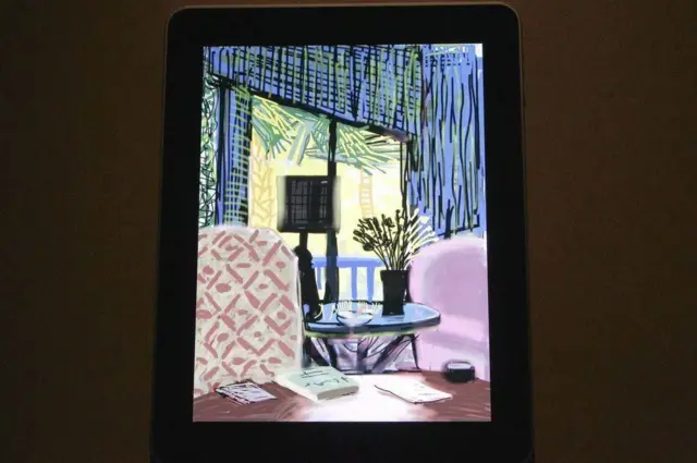 David Hockney resmi iPad'de. Resim mavi duvarlı ve kırmızı sandalyelere sahip bir odadan oluşuyor. Bu bir natürmort.