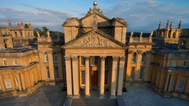 Una vista aérea de la luz solar dorada sobre parte del Palacio de Blenheim, mostrando altos pilares debajo de un frontón tallado.