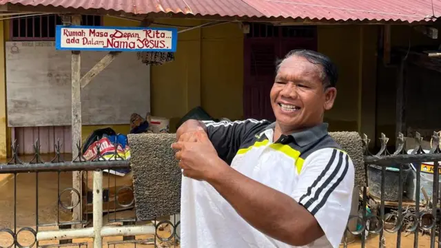 Pendeta Paten Sidabutar menunjukkan rumahnya di seberang gereja yang ikut terdampak banjir bandang.
