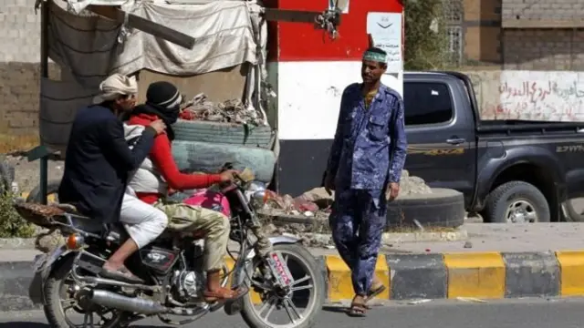دو موتور سوار از مقابل یک نیروی امنیتی در یمن می گذرد