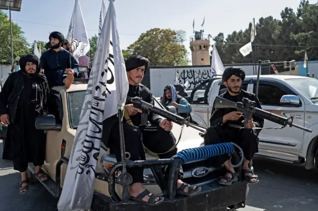 چهار مرد افراد طالبان با تفنگهای ام-۴ آمریکایی