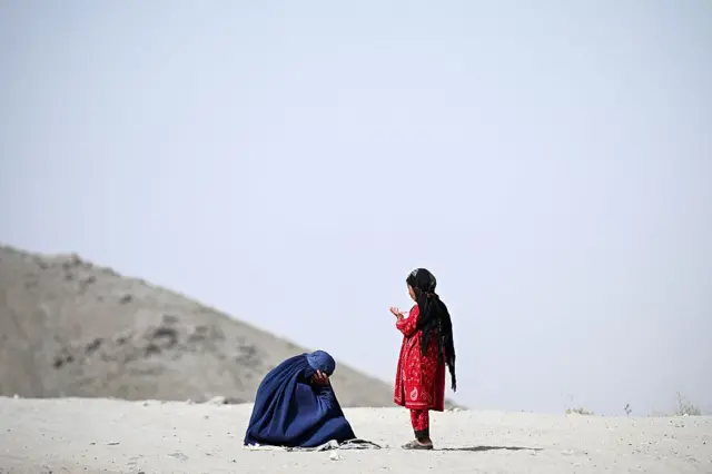 Una mujer con burka, y su hija con velo, en la mitad del desierto,