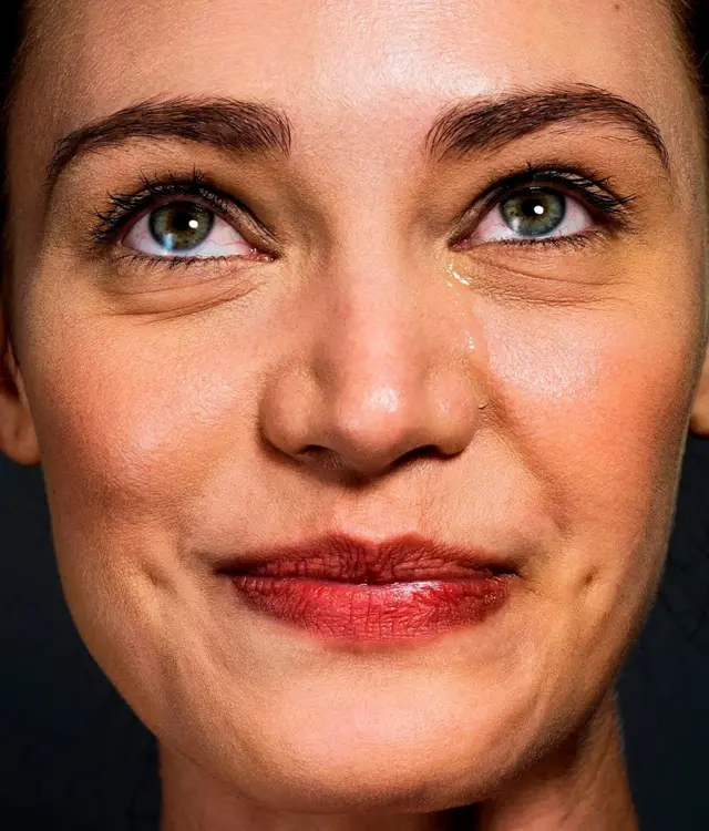 Жінка, яка посміхається крізь сльози