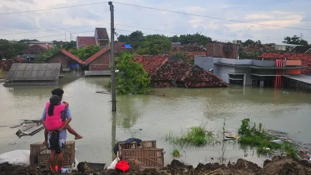 Warga menyaksikan rumah yang terendam banjir di Desa Ketanjung, Karanganyar, Demak, Jawa Tengah, Minggu (17/3/2024).
