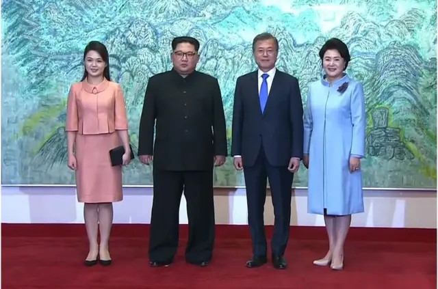 This screen grab from the Korean Broadcasting System (KBS) taken on April 27, 2018 shows North Korea"s leader Kim Jong Un (2nd L) and his wife Ri Sol Ju (L) posing for a photo with South Korea"s President Moon Jae-in (2nd R) and his wife Kim Jung-sook (R) at the end of their historic summit at Panmunjom.