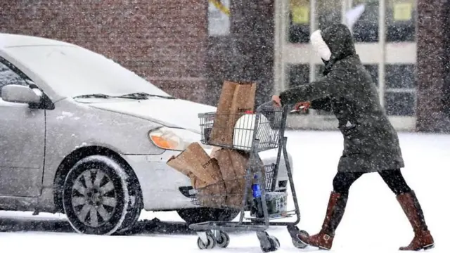 Una mujer desafía la tormenta para conseguir suministros en Bridgeport, Connecticut, el domingo.