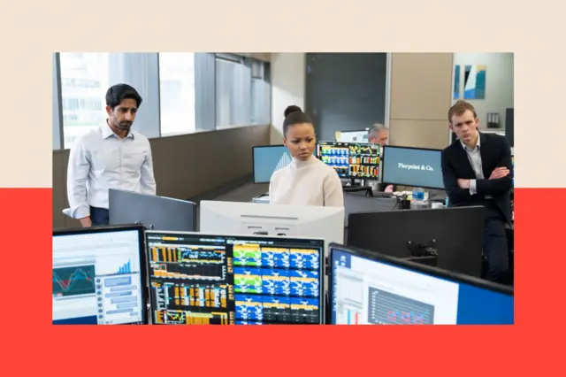 Tres personas están de pie en una oficina, mirando a lo lejos.