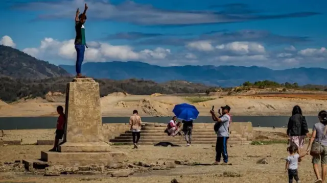 توریست‌ها از بقایی شهر بیرون زده از سد، بازدید می‌کنند