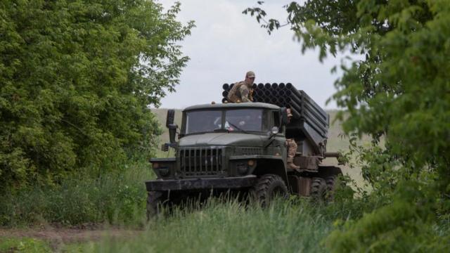 Ukrainian servicemen ride atop of a BM-21 Grad multiple launch rocket system near a front line in Donetsk region on 21 June