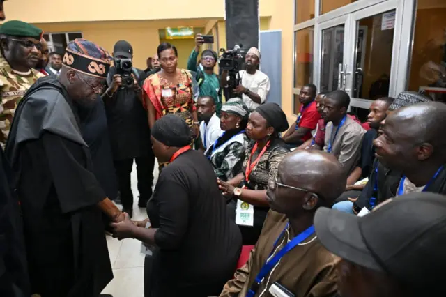 Tinubu wọ agbada dudu, o n ki obinrin to kunlẹ to wọ aṣọ dudu. Ọpọ eeyan wa lori ijokoo nibẹ