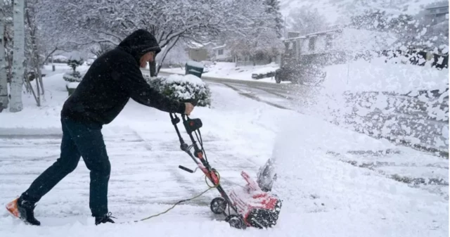 ইউটাহতে বরফ সরাচ্ছেন এক বাসিন্দা।