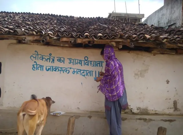 नारा लिखती एक महिला.