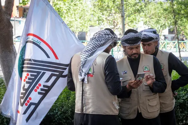 عناصر من الحشد الشعبي العراقي يقفون معاً خلال مشاركتهم في تجمع مناهض للولايات المتحدة وإسرائيل أمام السفارة العراقية في وسط العاصمة الإيرانية طهران، في 23 أبريل/نيسان 2026، وذلك بعد تمديد وقف إطلاق النار بأمر من الرئيس الأمريكي دونالد ترامب.