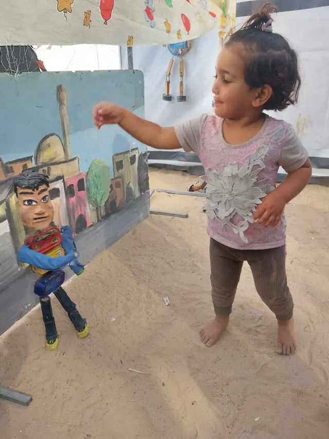 Una niña participa en un espectáculo de títeres en Gaza