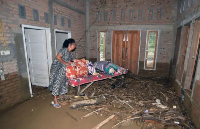Warga berada di rumahnya yang masih berlumpur akibat banjir bandang di Lapau Munggu, Kuranji, Padang, Sumatera Barat, Selasa (4/8/2026).