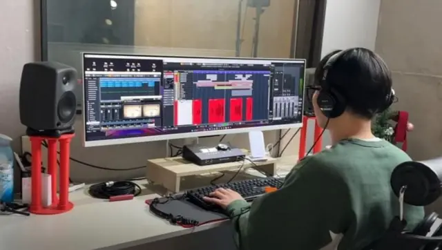 A sound engineer in front of a computer screen