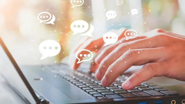 Manos de hombre tecleando en una computadora.