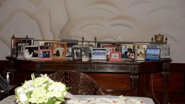 Fotografía de una mesa con retratos del fallecido financiero junto a personajes relevantes.