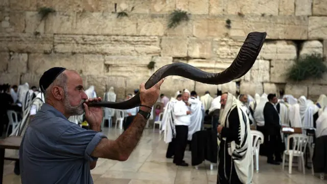 Un hombre judío tocando un cuerno en el Muro de los Lamentos de Jerusalén