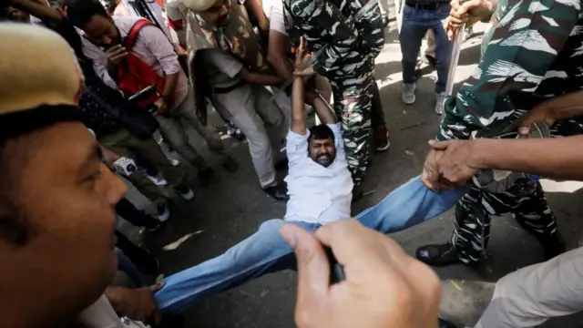 Police officers detain a supporter of India's main opposition Congress party during a protest in New Delhi, India