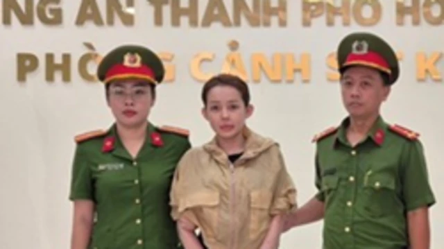 Hình ảnh của Ngân 98 bị xích chân, hai bên là hai nữ cảnh sát khiến dư luận xôn xao