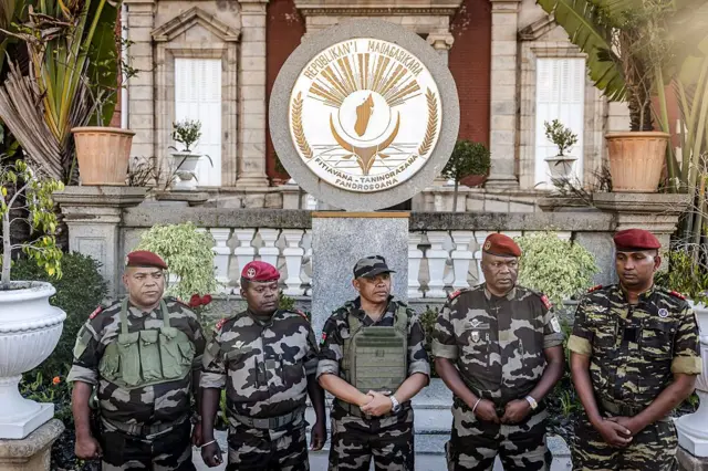 Korneyl Michael Randrianirina oo ka tirsan ciidamada milateriga ee CAPSAT, oo taagan agagaarka madaxtooyada Antananarivo isagoo ay weheliyaan xubno kale oo ka tirsan unuggaas, kadib markii uu akhriyay bayaan uu ku dhawaaqayo in ay la wareegayaan awoodda magaalada Antananarivo, Oktoobar 14, 2025.