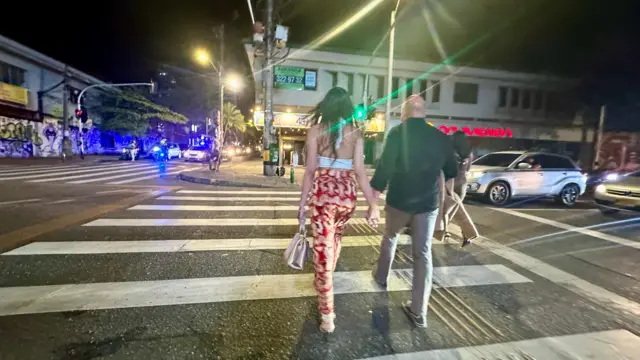 Extranjero acompañado de una joven colombiana en una calle de El Poblado.