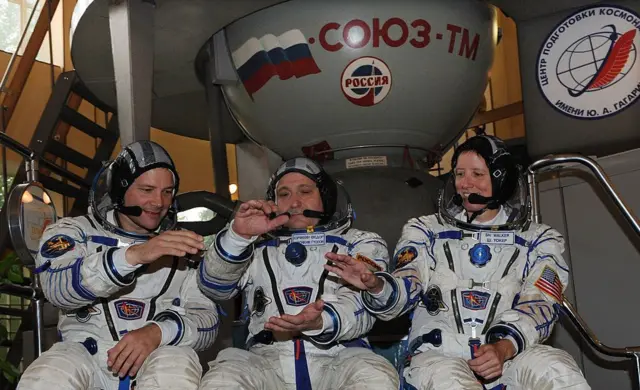 "Союз ТМА-19" космос кораблинин экипажы. Америкалык астронавт Даг Виллок (солдо), орусиялык космонавт Федор Юрчихин (ортодо) жана америкалык астронавт Шеннон Уокер (оңдо) космос станциясына учаар алдында тартылган сүрөт
