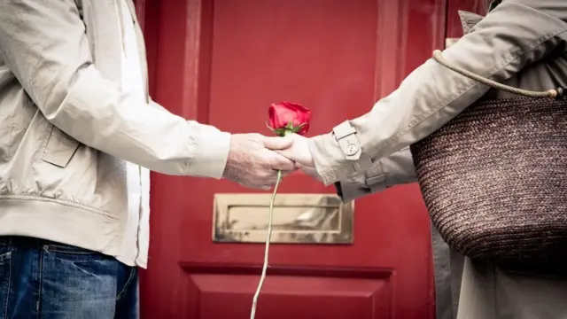 رجل وامرأة يمسكان بأيدي بعضهما البعض