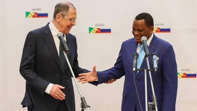 Le ministre russe des Affaires étrangères, Sergei Lavrov (G), serrant la main de Jean-Claude Gakosso, ministre des Affaires étrangères de la République du Congo (D), lors de leur conférence de presse conjointe dans la ville d'Oyo, au Congo, le 25 juillet 2022