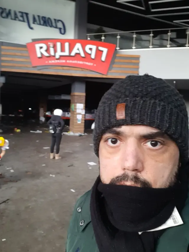 Devrim Çiner yağmalanan bir süpermarket önünde.