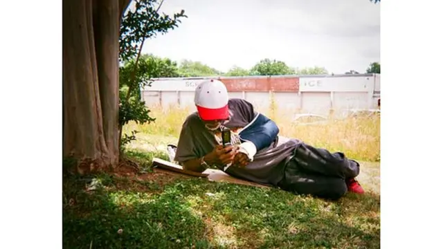 Hombre sentado bajo la sombra de un árbol