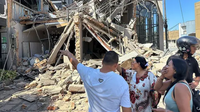 Em Pereira, moradores de uma rua observam, perplexos, os danos causados ​​pelo terremoto em diferentes propriedades.