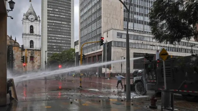 Un camión dispara agua contra un manifestante en Bogotá el 5 de mayo.