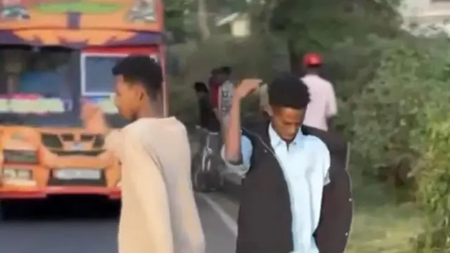 Waa sawir muuqaal laga jaray oo muujinaya wiil dhalinyaro ah oo muuqaal iska duubaya gaari ku dhacayo