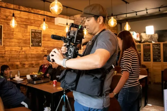 阿軍拍攝時要身兼多職，一人主理燈光、收音和兩部拍攝不同角度的相機。