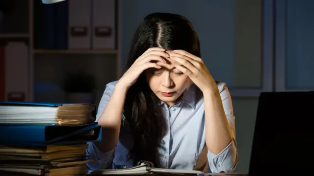 Woman at work with her head in her hands