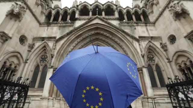 Guarda-chuva com logo da União Europeia em frente ao prédio da Alta Corte, em Londres