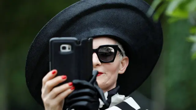 Женщина в шляпе делает селфи