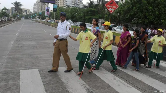 પ્રજ્ઞાચક્ષુઓને રસ્તો પાર કરાવી રહેલા પોલીસ કર્મચારી