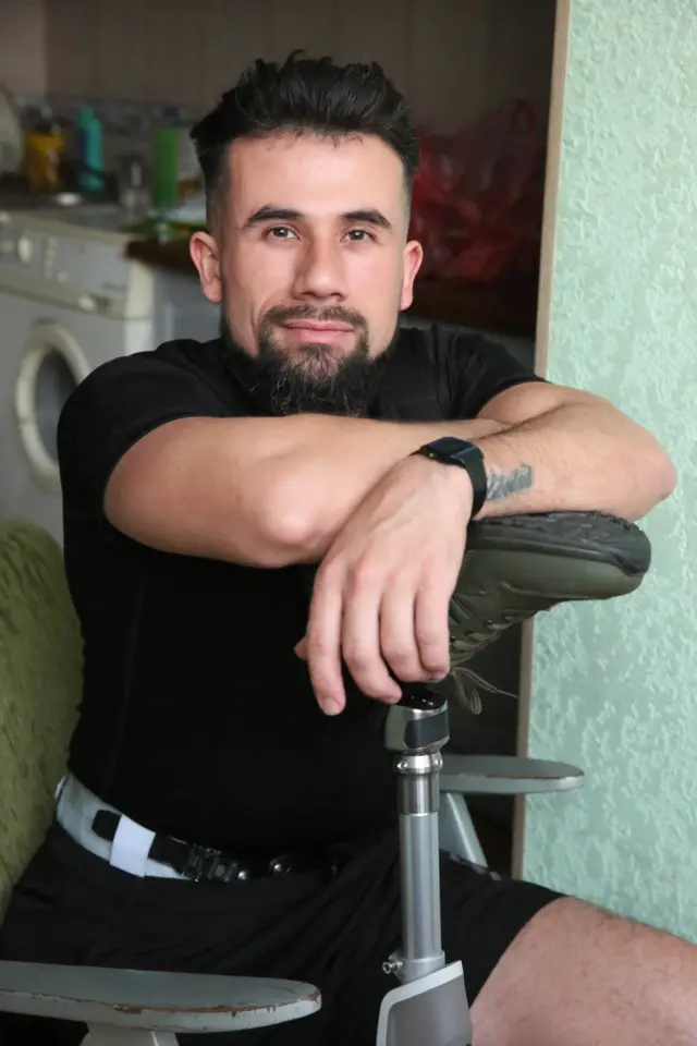 Арабе сидит, опираясь на свой протез 