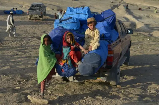 Des enfants afghans à côté d'un pickup