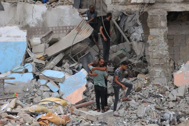فلسطينيون يبحثون عن ناجين تحت أنقاض منزل دمرته غارة جوية إسرائيلية في رفح جنوب قطاع غزة