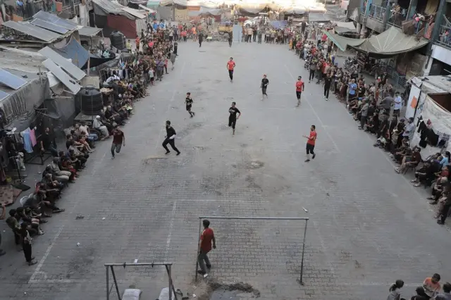 Jóvenes jugando fútbol en un patio

