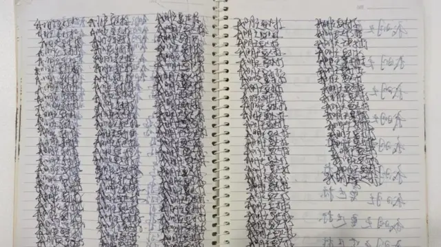 دفترچه‌ای که در آن یک کارگر صدها بار یک عبارت خاص را به زبان چینی نوشته است