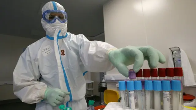 Un personal de la salud sostiene tubos de análisis.